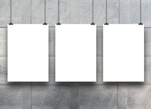 Three hanged paper sheets with clips on blue metal lamina background