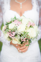 Beautiful wedding bouquet in hands of a bride. Selective focus.