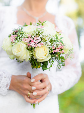 Beautiful wedding bouquet in hands of a bride. Selective focus.
