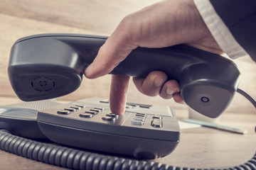 Closeup of businessman making a telephone call by dialing a phon - obrazy, fototapety, plakaty
