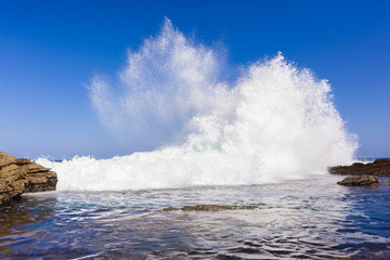Obraz premium Wave Exploding Water power along rocky coastline