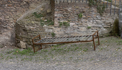 abandoned oldfashioned iron bed in the street of Rome