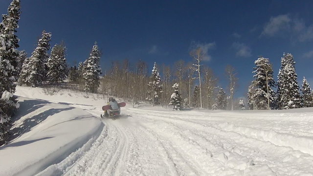 Snowmobile snowboarder ride up mountain P HD 0003