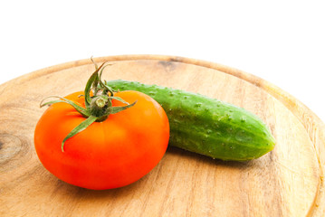tomato and cucumber on wooden cutting board