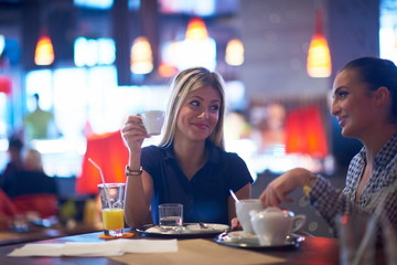 girls have cup of coffee in restaurant