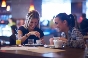 girls have cup of coffee in restaurant