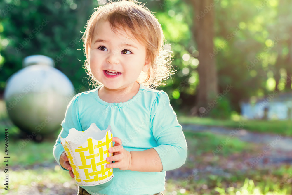 Wall mural Happy toddler girl smiling outside