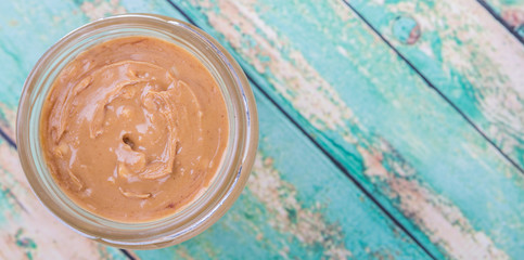 Peanut butter in a mason jar over wooden background
