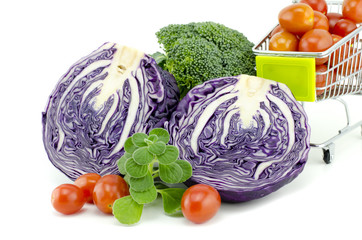assorted image of raw and fresh vegetables.purple cabbage, cherry tomatoes on trolley, green mint and green broccoli  isolated white background