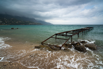 Old jetty on the beach in Ipsos. Corfu. Greece