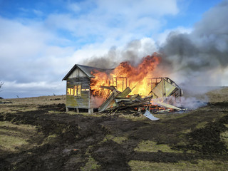 Old house on fire burning down with orange flames