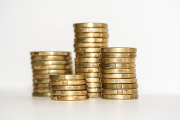 Stack of gold coins, Four columns of Australian one dollar and two dollar coins isolated on white.