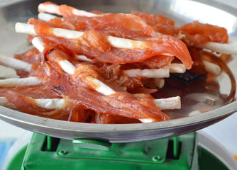 dog snack chicken jerky on stainless weighting scale tray