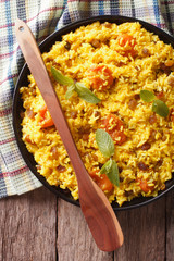 sweet rice with saffron and dried fruits close-up. vertical top view
