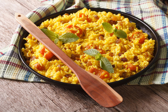 Delicious sweet rice with saffron and dried fruits close-up. horizontal
