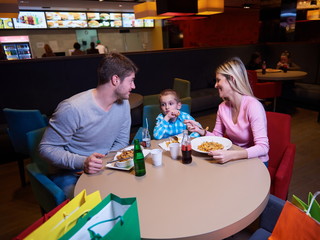 Obraz na płótnie Canvas family having lunch in shopping mall