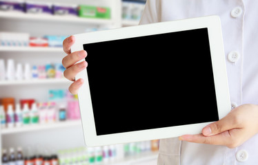 female Pharmacist shows an tablet computer at the drugstore