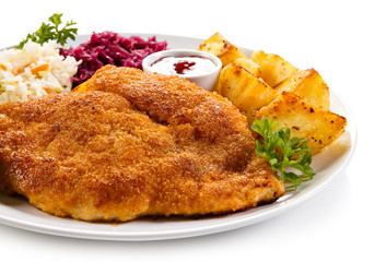 Fried pork chop, baked potatoes and vegetable salad 