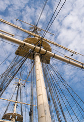 Fototapeta premium Wooden sailship rigging against blue sky with clouds