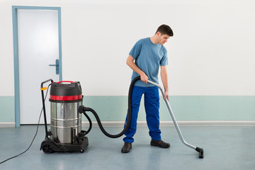 Male Worker With Vacuum Cleaner