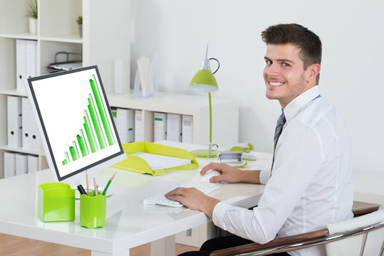 Young Businessman Analyzing Graph On Computer