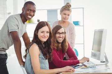 Fototapeta premium Portrait of happy business team working at computer desk 