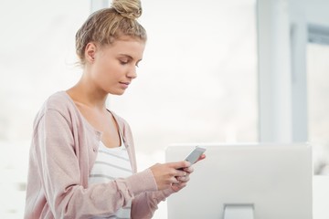 Fototapeta premium Woman using smartphone in office