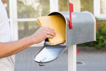 Person Removing Letters From Mailbox