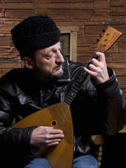 Russian musician touching a balalaika