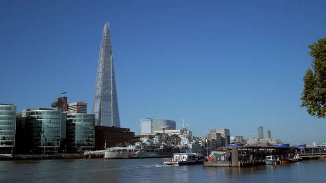 Static shot of The Shard, City Hall and HMS Belfast taken from the north bank of the Thames. Footage is 4K original and shot on a clear sunny autumn morning as a Thames river boat passes