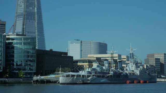 Tilt down the Shard in London to HMS Belfast taken from the north bank of the Thames. Footage is 4K original and shot on a clear sunny autumn morning