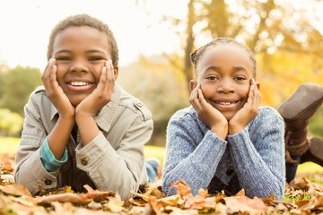 Portrait of young children lying in leaves