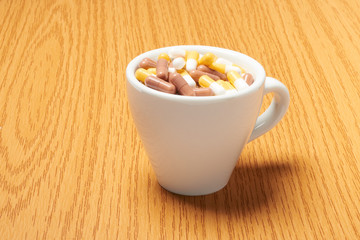 Pills capsules of medicament in coffee cup