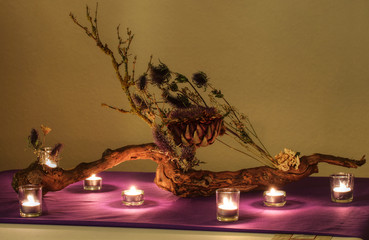 Tischdeko aus dem Baumwurzel und getrockneten Blumen