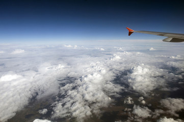 Wing of the Airbus above the clouds in the sky, view from above the clouds, flying over clouds in a plane, the boundless space, the atmosphere and the stratosphere, meteorology.