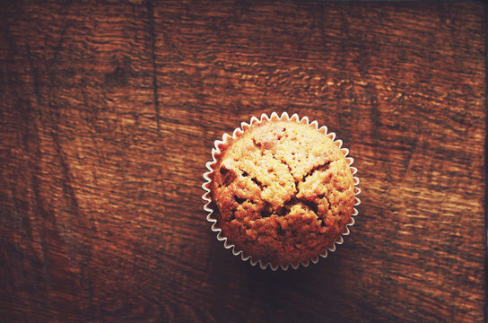 Homemade carrot muffin with empty space on brown wooden backgrou