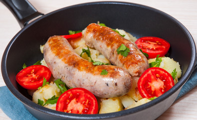Potatoes with sausages in a frying pan