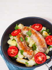 Potatoes with sausages in a frying pan
