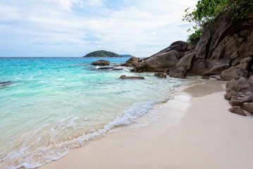 Beautiful landscape of blue sea sand and white waves on small beach near the rocks during summer at Koh Miang island in Mu Ko Similan National Park, Phang Nga province, Thailand