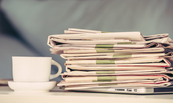 Stack of newspapers with a cup of coffee
