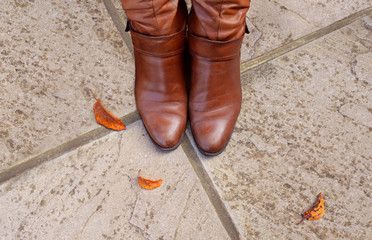 Toes of tan leather boots on a concrete