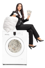 Businesswoman laundering money in a washing machine