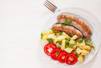 Potatoes with sausages on plate