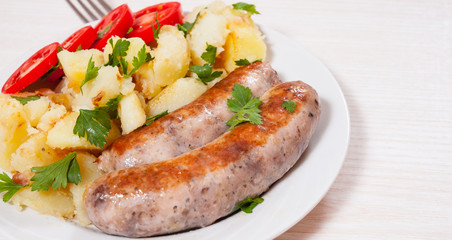 Potatoes with sausages on plate