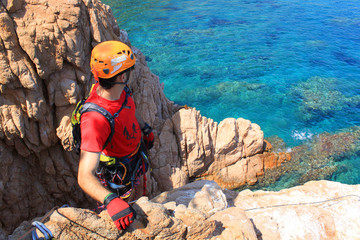 guy in a via ferratas looking at the sea