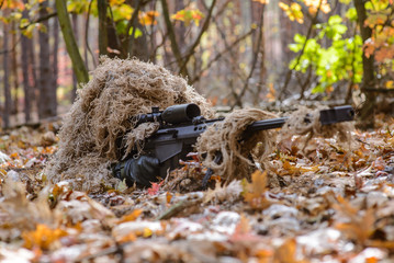 Sniper hide in forest with large-caliber rifle