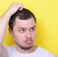 Obraz premium Portrait of funny cluelles man against yellow background