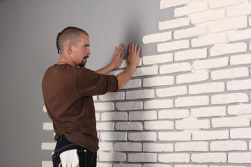 Builder applying tile on a wall