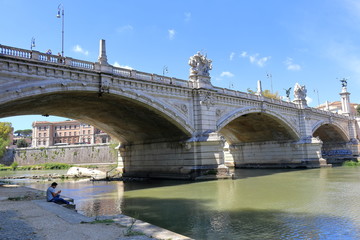 Man listening to music under the Ponte Vittorio Emanuele II in Rome, Italy
