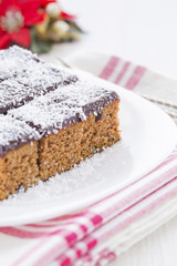 Coconut cubes for New Year'a Day on the white plate with silver forks, candle and Christmas decoration